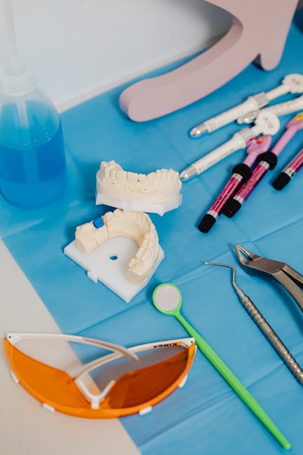 Close-up of dental equipment and molds on a blue surface indicating a dental procedure setup.